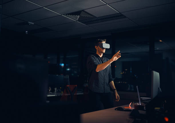 Person wearing VR headset explores virtual environment in a dark room, illustrating VR's impact on entertainment.